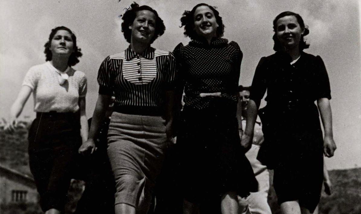 Cuatro mujeres caminando con paso firme y sonriendo